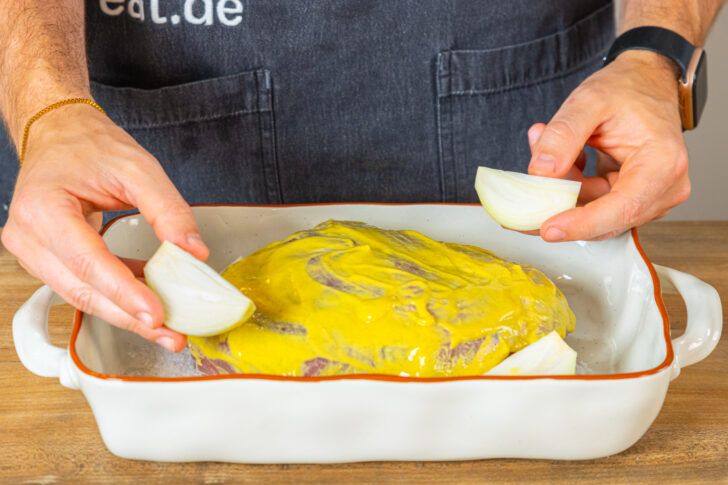 Zwiebel und Knoblauch in Auflaufform geben