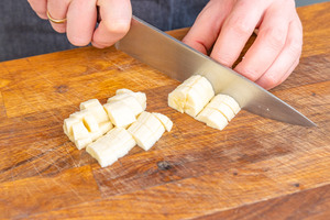 Für das Topping wird eine Banane in kleine Stücke geschnitten