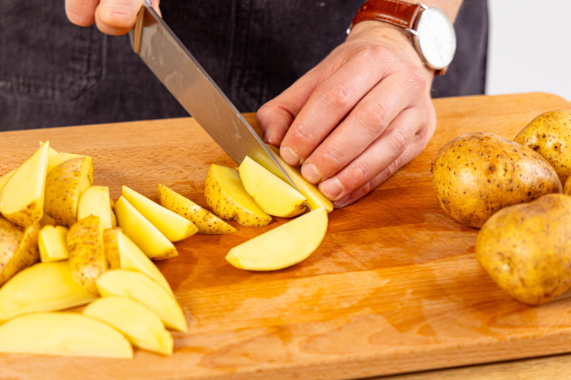 Kartoffeln waschen, trocken tupfen und in Spalten schneiden