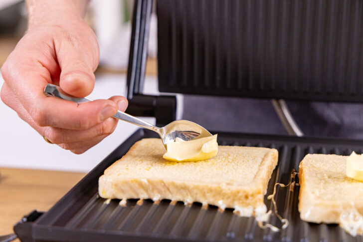 Stück Butter auf Toast legen