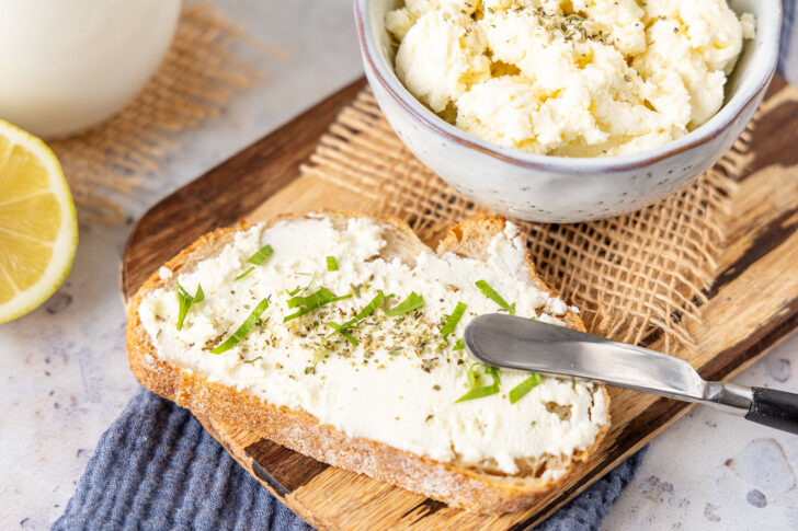 Frischkäse auf Brot streichen