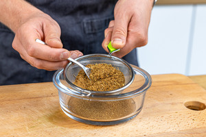 Garam Masala Gewürz durch ein Sieb geben