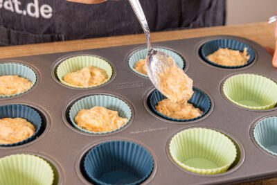 Teig für Gemüsemuffins in Muffinmulden füllen