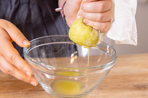 Zucchini durch ein Passiertuch ausdrücken