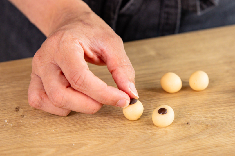 Schokotröpfchen auf Marzipankugeln mittig platzieren