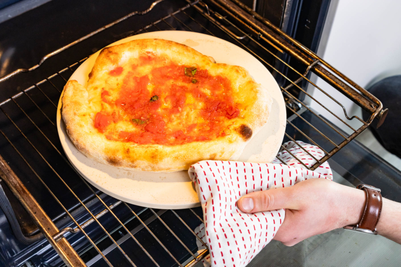 Pizza Marinara auf einem Pizzastein im OFen backen