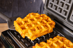 goldgelbe Pizzawaffeln aus dem Waffeleisen nehmen