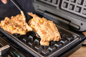 Waffelteig ins Waffeleisen geben