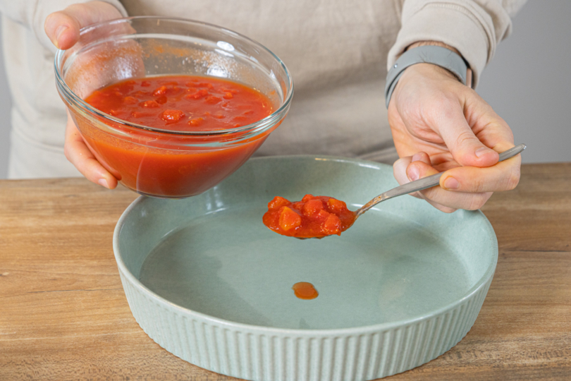 Passierte Tomaten in Auflaufform geben