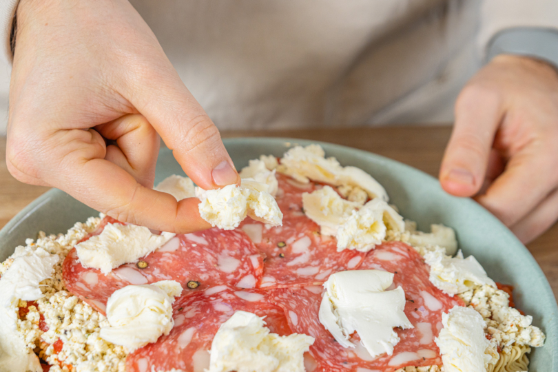 Mozzarella auf Lasagne geben