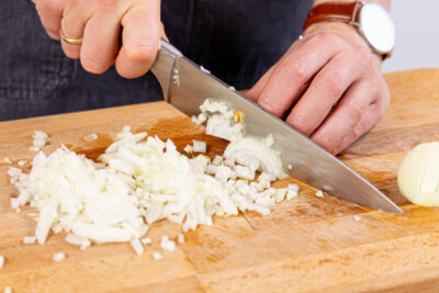 Zwiebeln und Knoblauch in Würfel schneiden