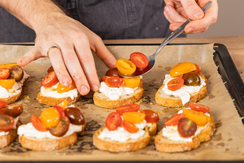 Tomaten auf die Crostini geben