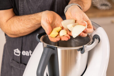 Zwiebeln, Ingwer und Knoblauch in den Mixtopf geben