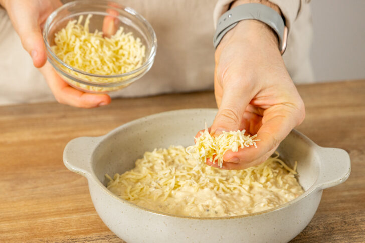 Käse über Auflauf geben