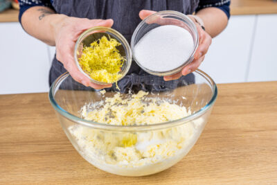 Zitronenschale und Zucker zur Butter geben