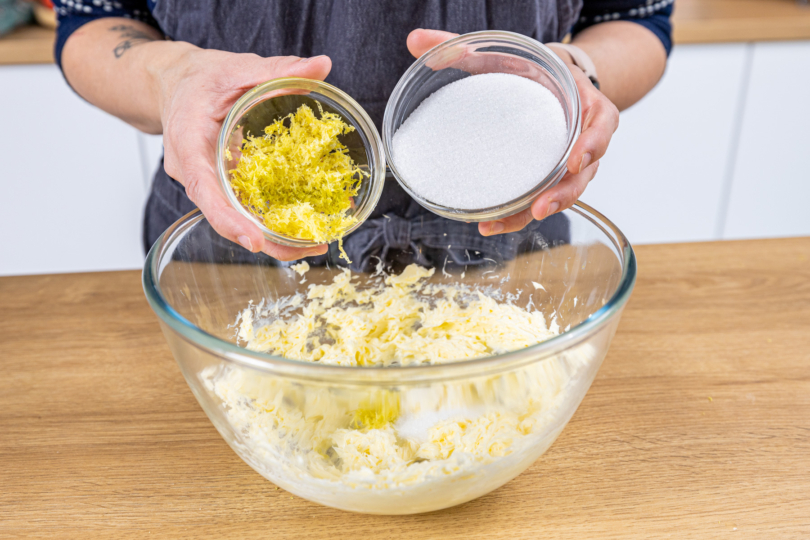 Zitronenschale und Zucker zur Butter geben