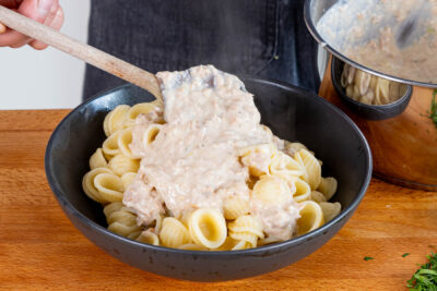 Thunfischsauce über die Nudeln geben