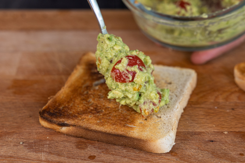 Avocadocreme auf dem Toast verteilen