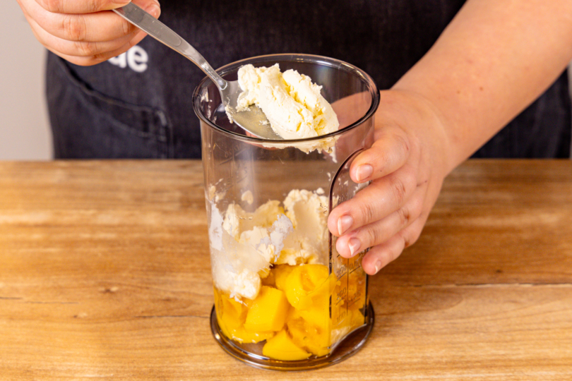 Mango und Frischkäse in MIxbecher geben