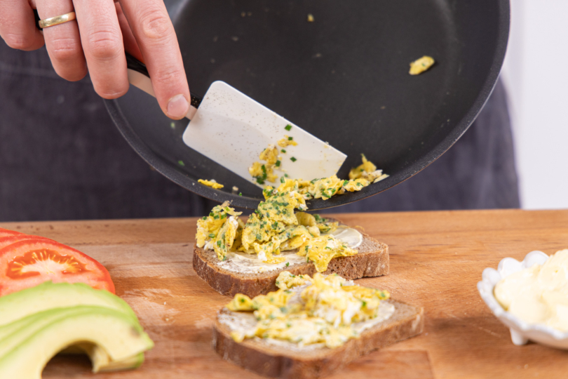 Rührei auf dem Brot verteilen