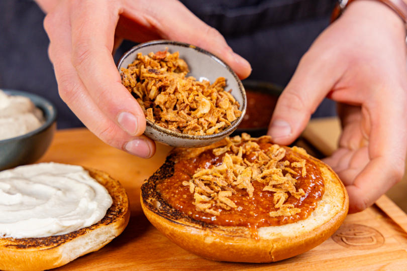 Röstzwiebeln auf Burger-Sauce geben