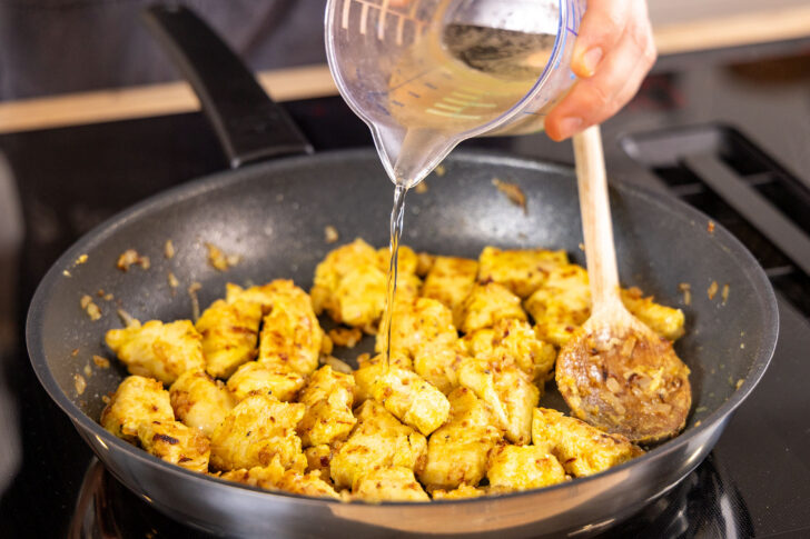 Weißwein zum Fleisch in die Pfanne gießen