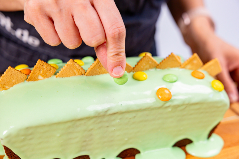 Dino-Kuchen mit Schokolinsen dekorieren