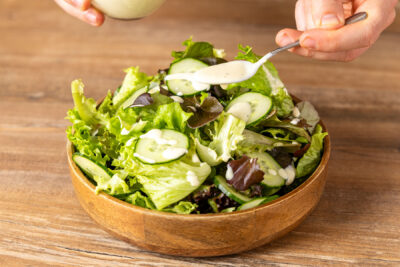 Dressing über den Salat verteilen