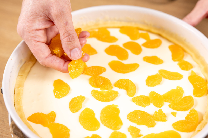 Mandarinenstücke auf dem Faule-Weiber-Kuchen verteilen