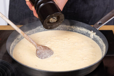 Crème fraîche in die Soße rühren und diese abschmecken