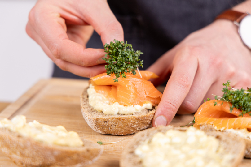 Lachsbrötchen mit Kresse toppen