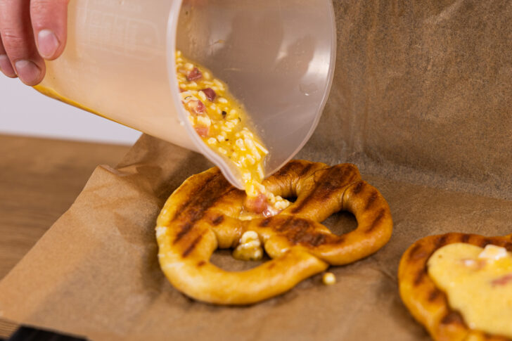 Käse-Ei-Masse auf den Brezeln verteilen