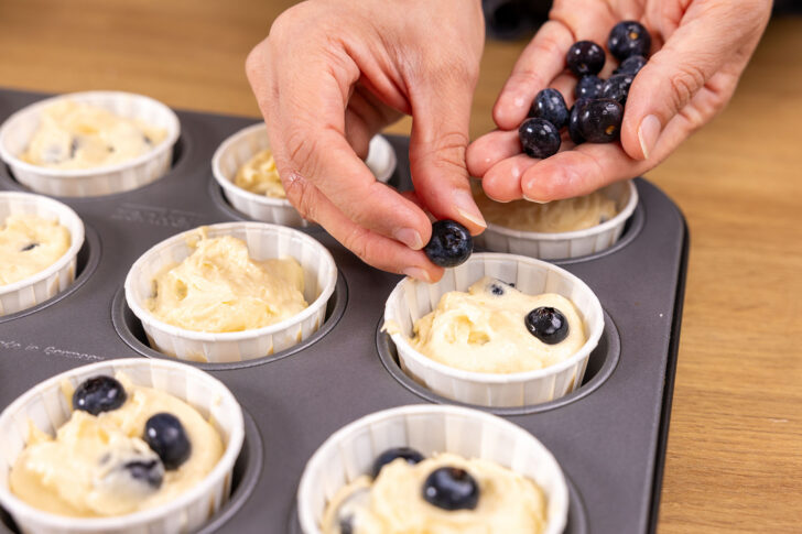 Beeren auf den Blaubeermuffins verteilen