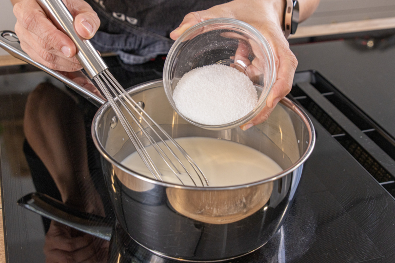 Zucker und Milch im Topf aufkochen