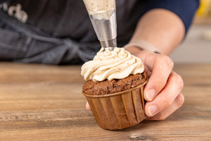 Erdnussbutter auf Muffins spritzen