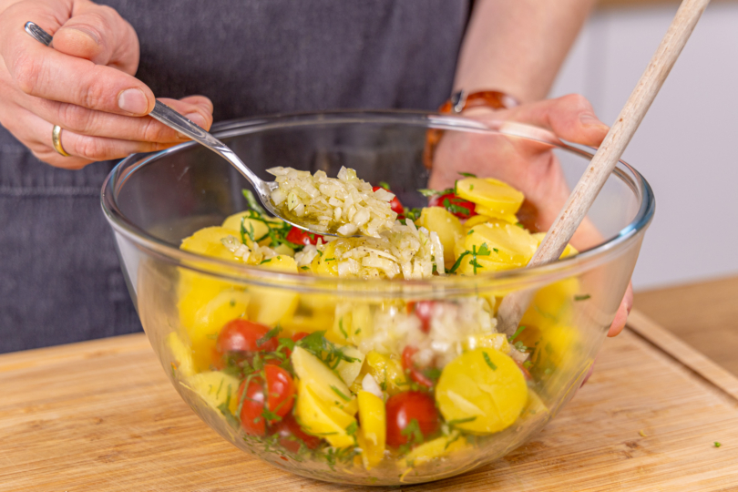 Kartoffelsalat mit den Sherry-Zwiebeln mischen