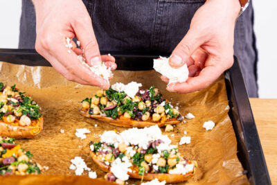 Gefüllte Süßkartoffeln mit Feta bestreuen und noch einmal backen