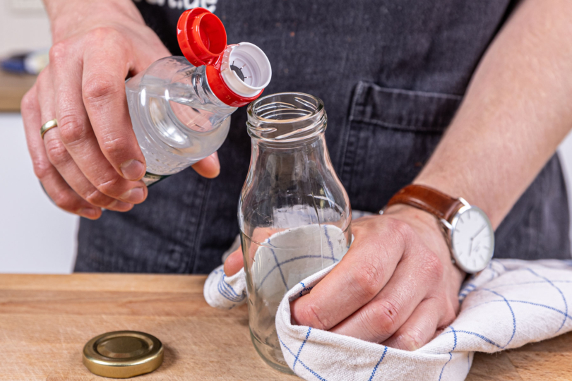 Essig in die Flasche geben