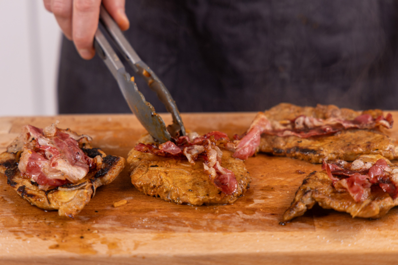 Bacon auf den Steaks verteilen