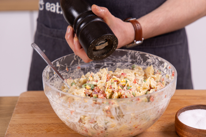 Veganen Nudelsalat mit Salz und Pfeffer abschmecken