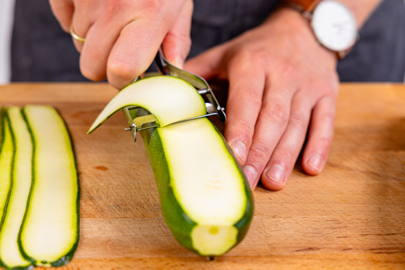 Zucchini mit dem Sparschäler in Scheiben schneiden