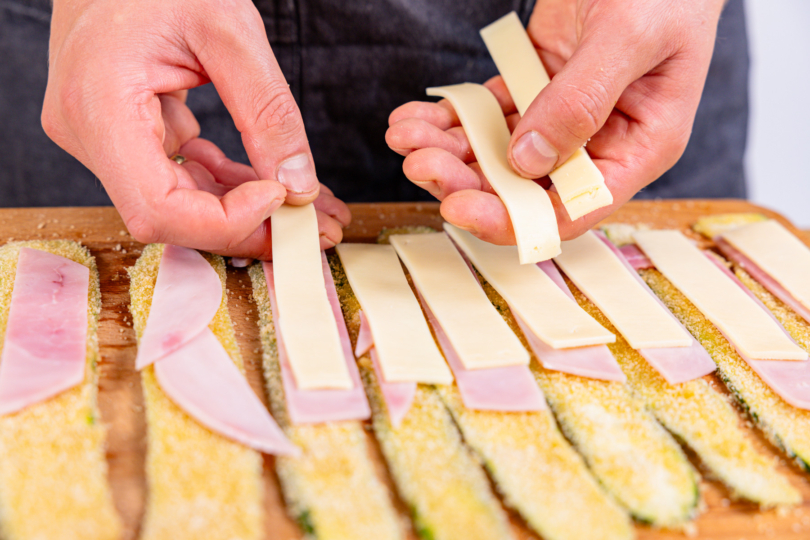 panierten Zucchini mit Schinken und Gouda belegen