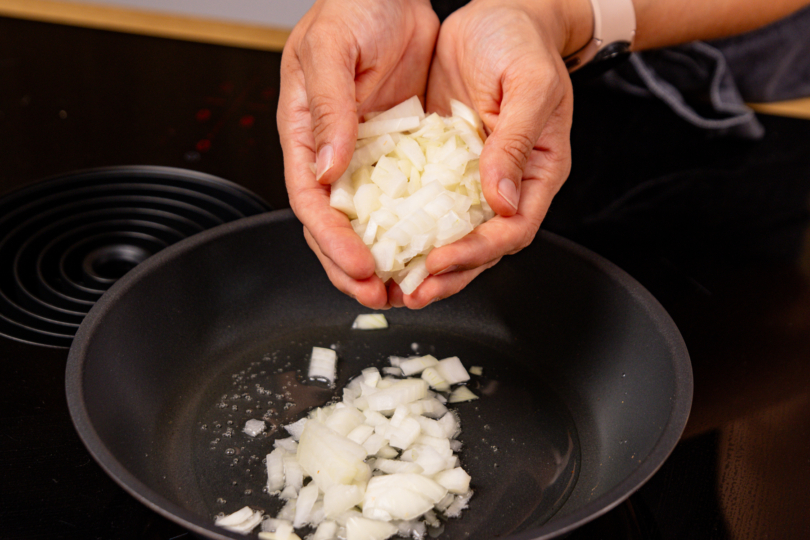 Zwiebelwürfel ins heiße Öl geben