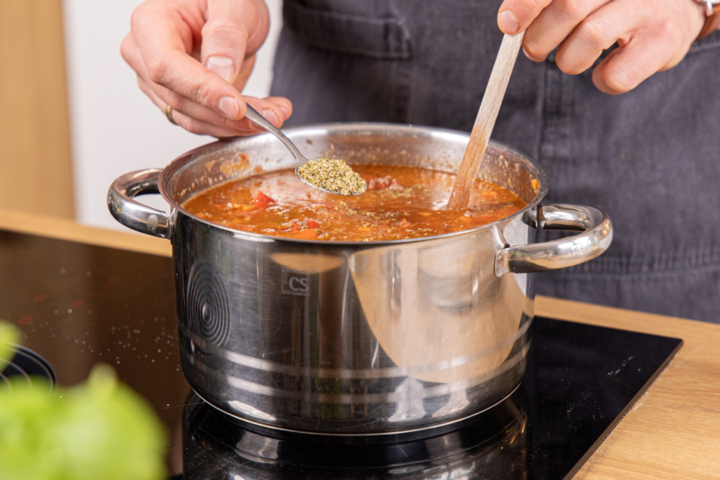 Bolognese-Eintopf mit Oregano würzen