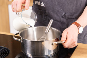 Milch in einem Topf gießen