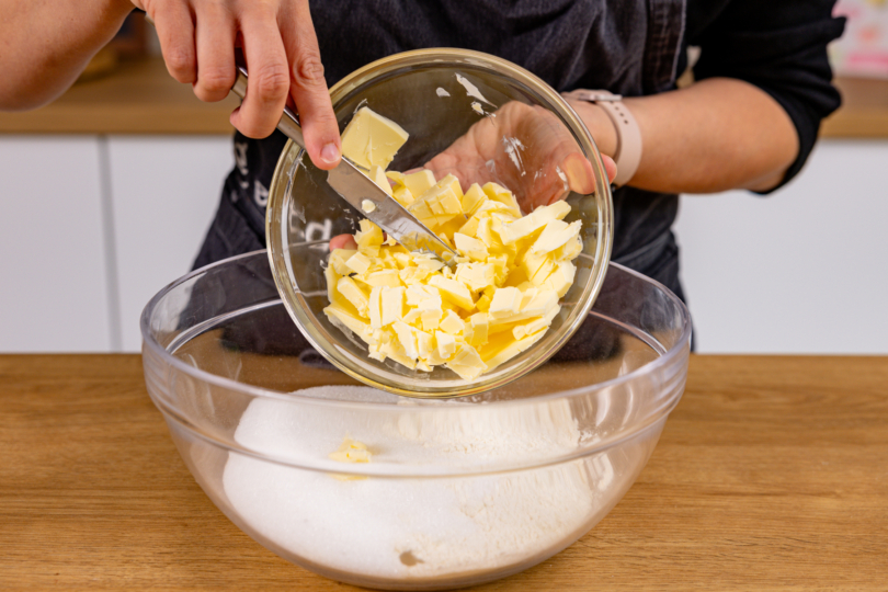 Butterflocken zu Zutaten für Mürbeteig in Schüssel geben