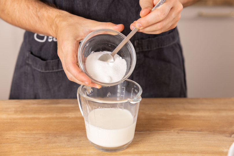 Zucker in Milch geben.