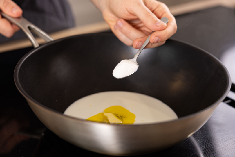 Zucker zu Milch und Butter in die Pfanne geben.