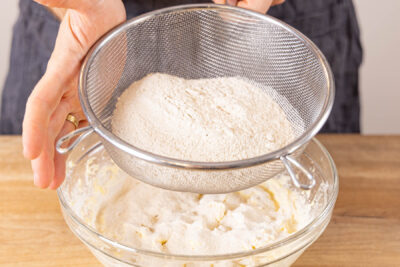 Mehl und Backpulver sieben für glutenfreien Zitronenkuchen