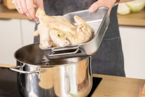 Huhn aus dem Topf nehmen